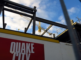 An advert for the Quake City attraction amidst the cranes and steel