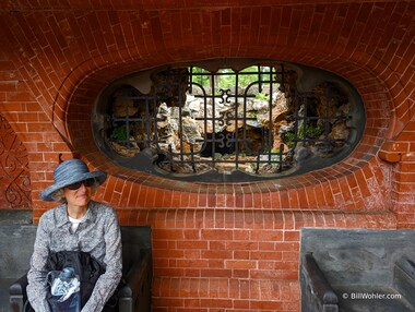 Lori pauses in the Summerhouse that has a grotto with running water in the background