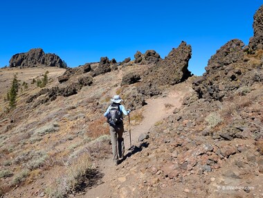 Lori hikes through aggregate boulders and a Martian landscape