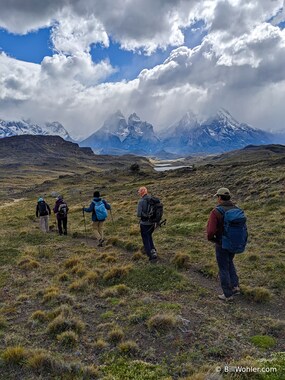 Carlos, Lori, Mark, Christine, and José hike on with a beautiful backdrop
