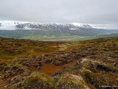 The fog lifts ever so slightly so that we can see the snow-covered mountains on the other side of the valley