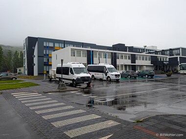 The outside of the modern Fosshotel H&uacute;sav&iacute;k with our bus in the front in the rain